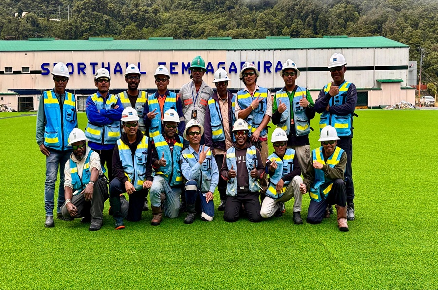Facilities & Town Management workers pose at the Tembagapura Football Field with new synthetic grass