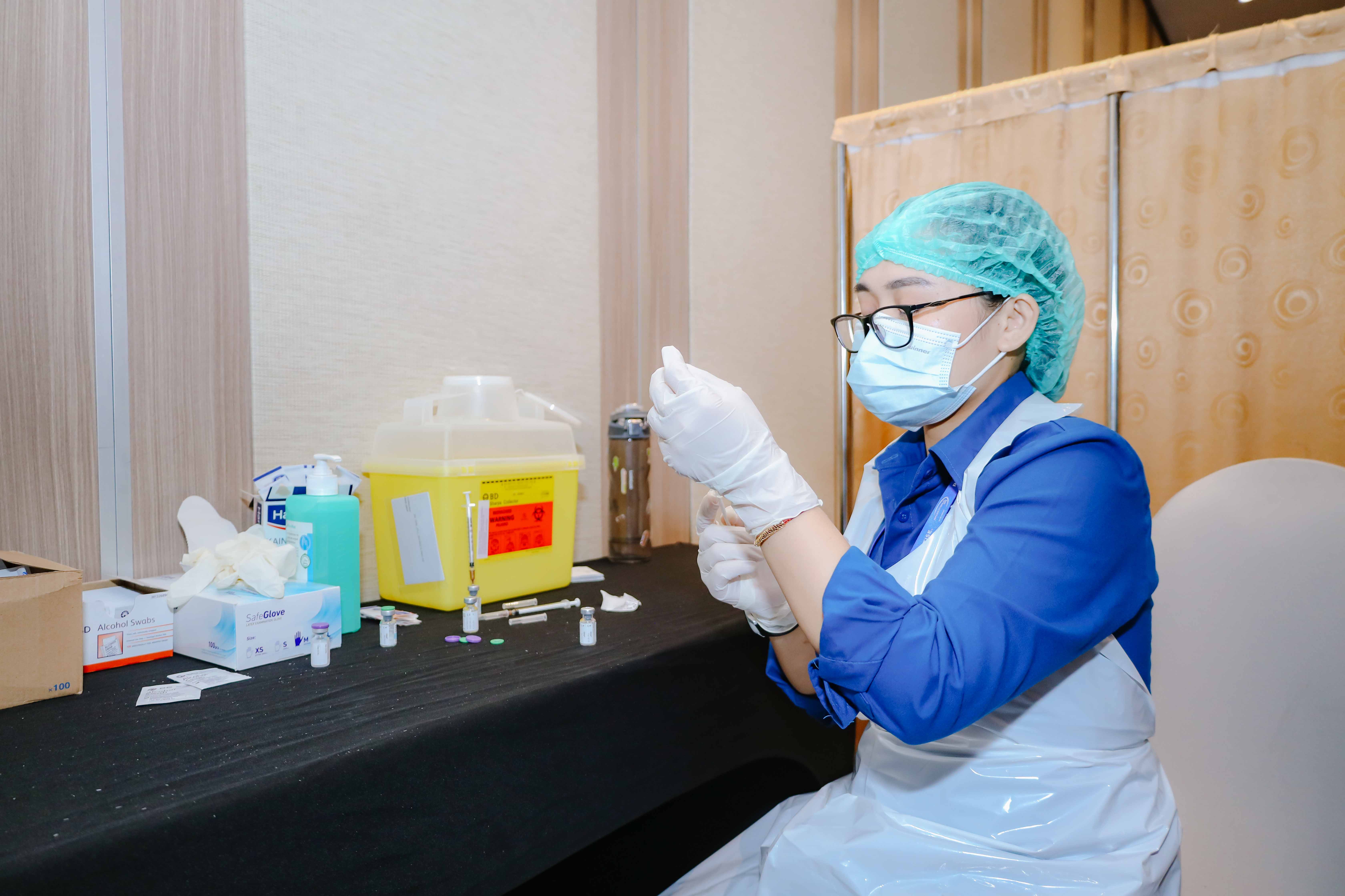 Tim medis sedang menyiapkan vaksin untuk para peserta vaksin.